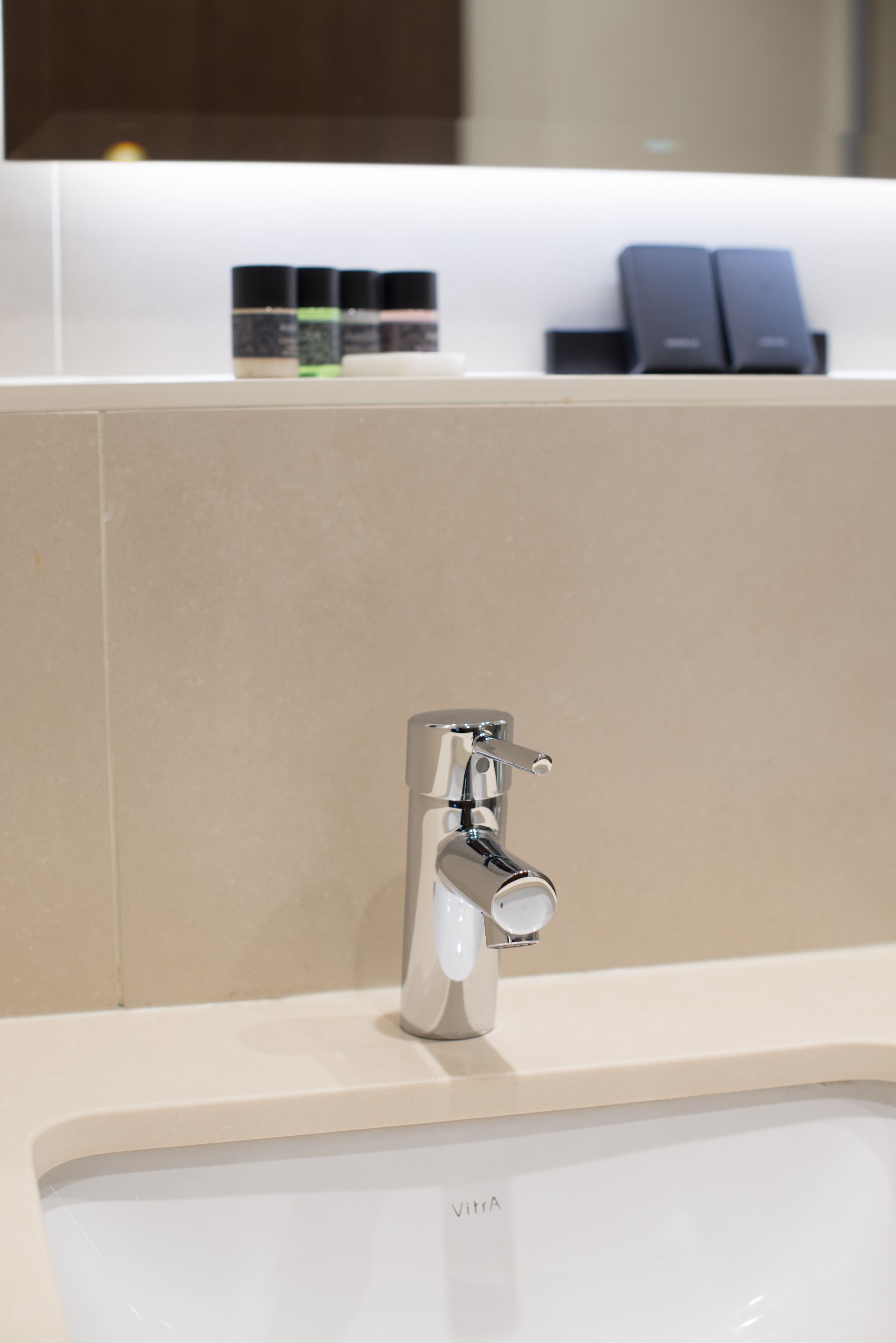 A modern bathroom with a chrome faucet and a white sink.