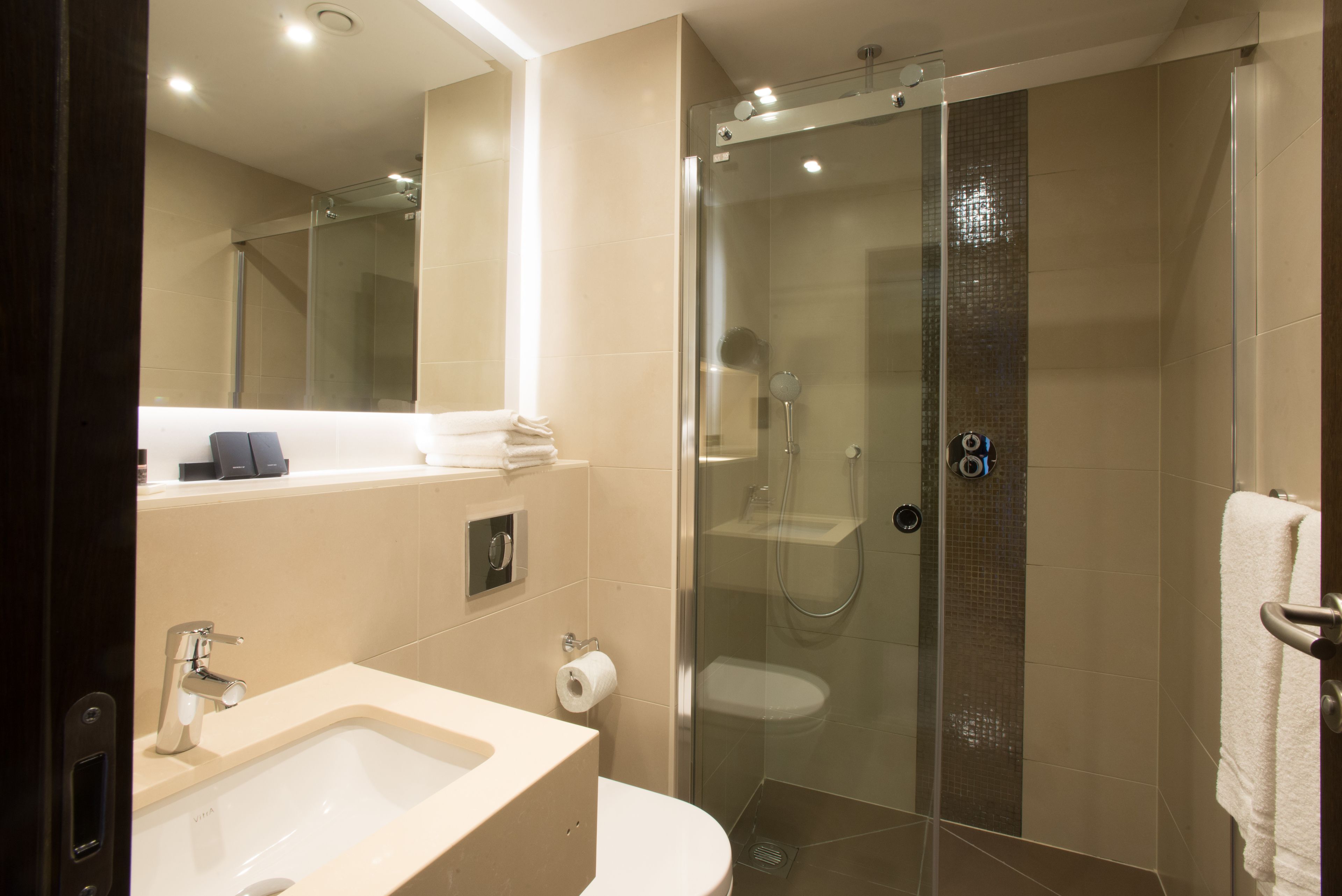 Une salle de bain moderne avec une douche à parois de verre, un lavabo et des toilettes.
