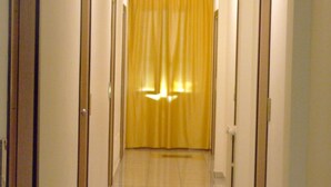 A hallway with a yellow curtain at the end, leading to a room.