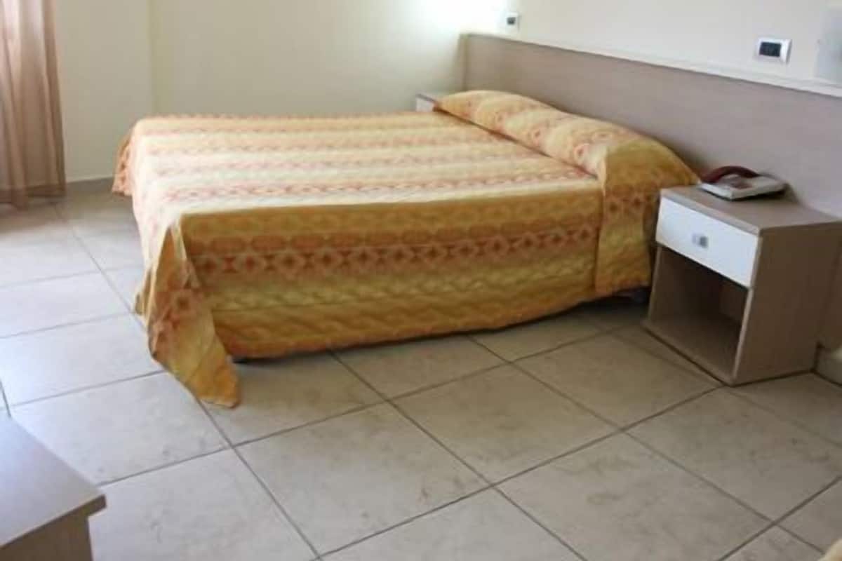 A room with a bed, a nightstand, and a small table.