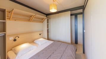 Een slaapkamer met een bed, een hanglamp en een kledingkast.