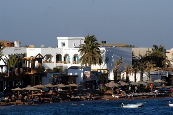 Trên bãi biển, ghế dài tắm nắng, dù trên bãi biển, khăn tắm biển