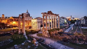 Ancient ruins with columns and a dome, surrounded by modern buildings and a pathway. - B&B Girasole (Rome)