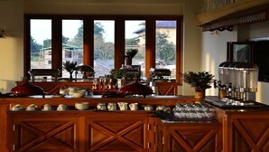 A kitchen with wooden cabinetry, a coffee machine, and a view of the outside.