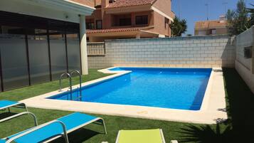 Alberca al aire libre y camastros