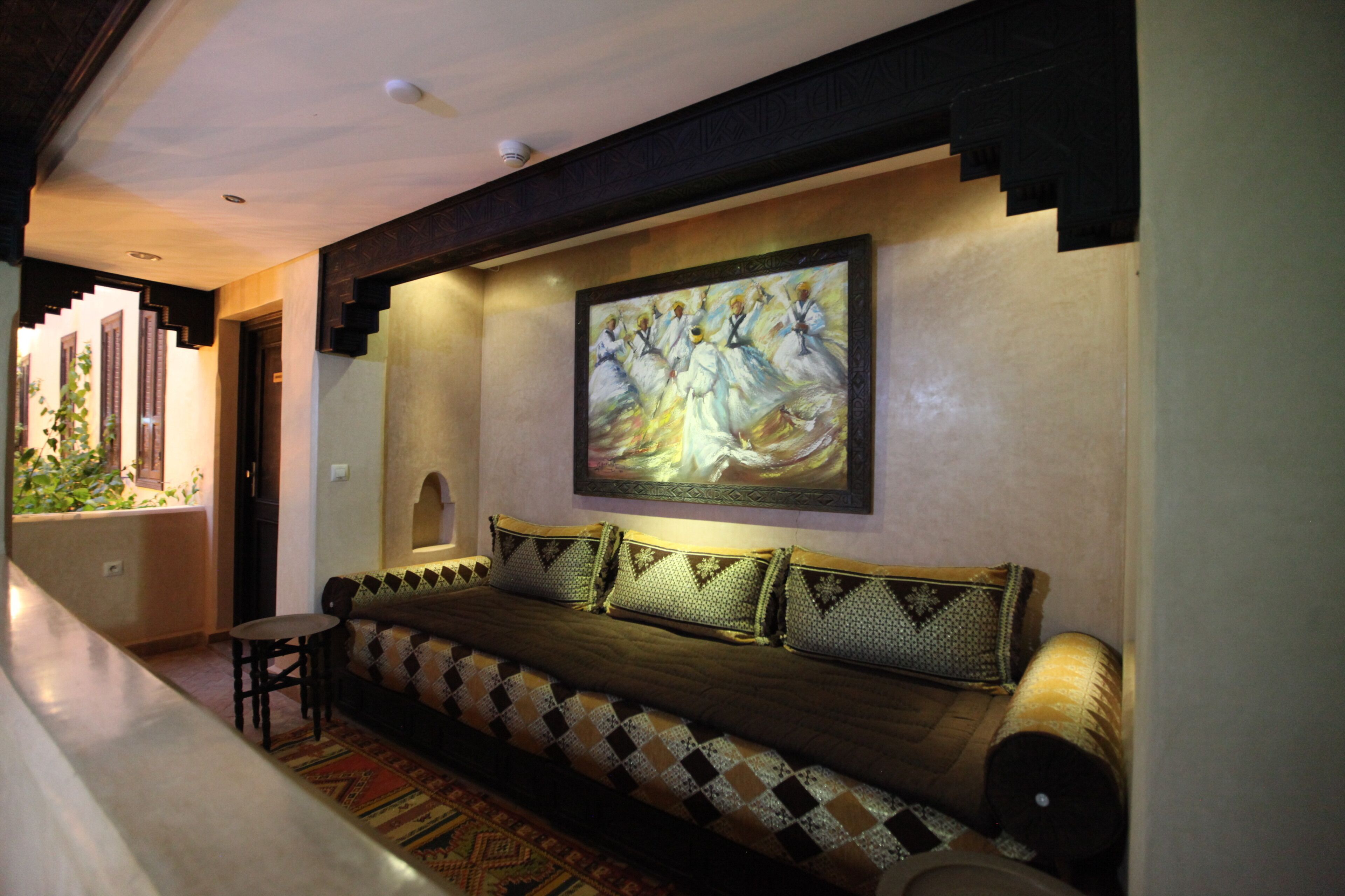 A hallway with a sofa, a small table, and a painting on the wall.