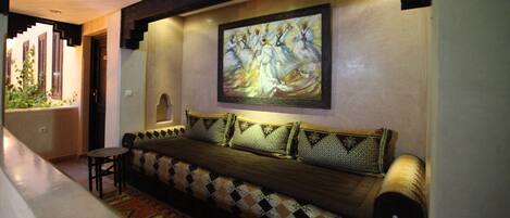 A hallway with a sofa, a small table, and a painting on the wall.