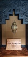Una habitación con un panel decorativo en la pared y un certificado enmarcado en el suelo.