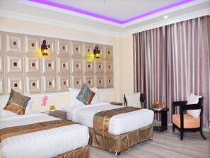 A hotel room with two beds, a large decorative wall, a seating area with a chair, and a curtain. - Mingalar Hotel (Mandalay)