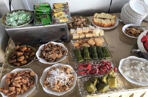 A buffet table with various food items including bread, cookies, and different types of meat and vegetables.