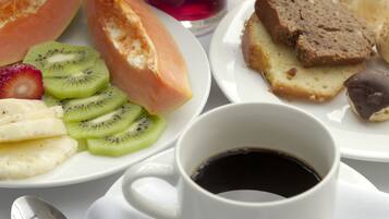 Desayuno con frutas variadas, pan y bebidas.