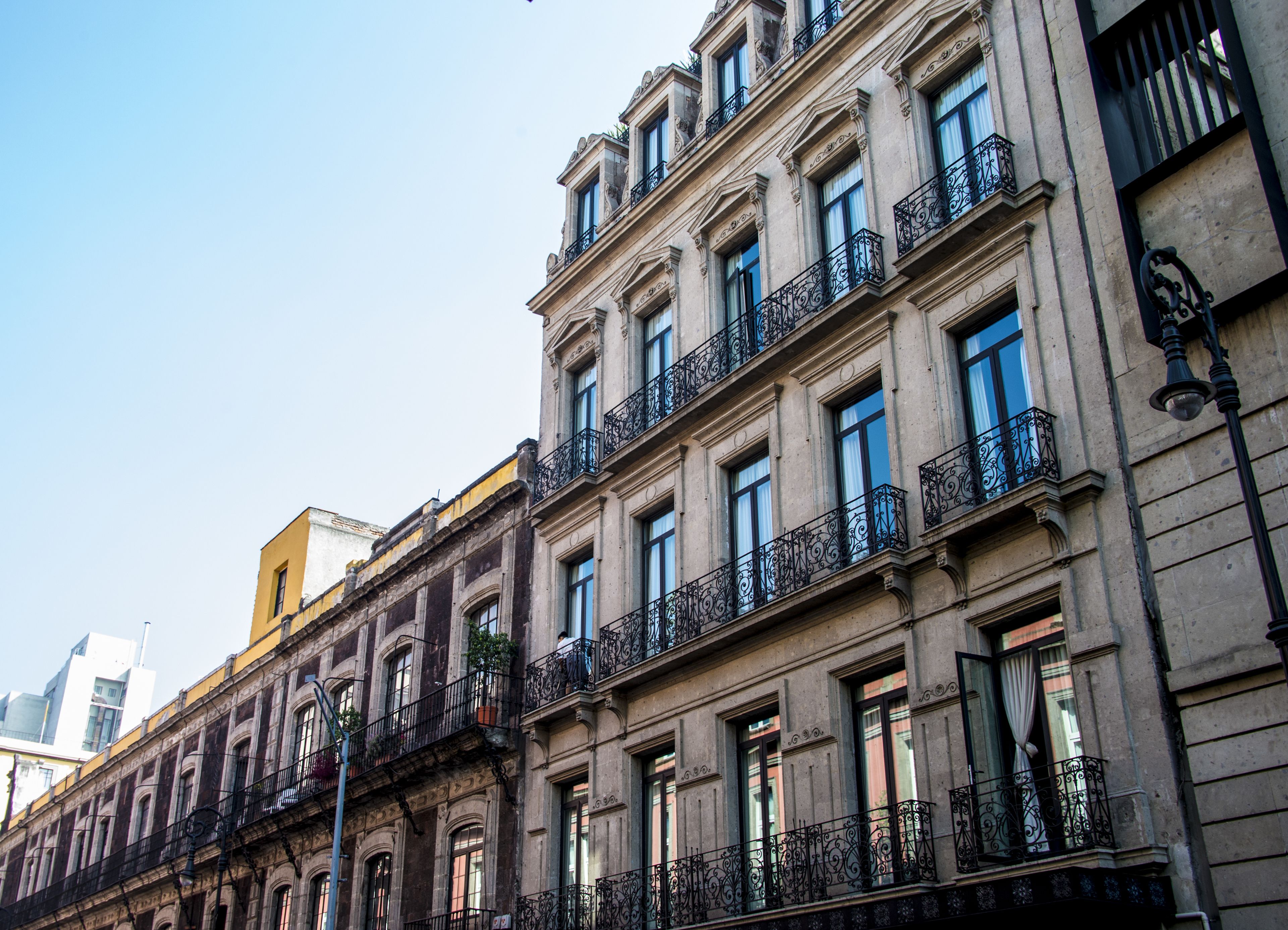 Un immeuble à plusieurs étages, doté de balcons décorés et de grandes fenêtres.