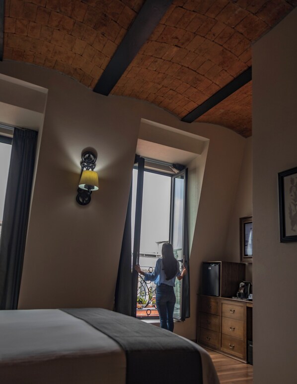 A bedroom with a bed, a dresser, a lamp, and a window. - Historico Central Hotel (Mexico City)