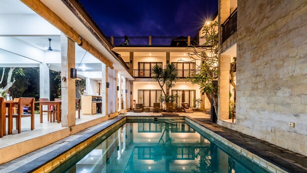 A modern hotel with a central swimming pool, outdoor seating, and a two-story structure with balconies. - Balian Paradise Hotel (Selemadeg)