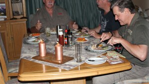 A dining table with candles, plates of food, and condiments. - Tshimologo Farm Guest House (Francistown)