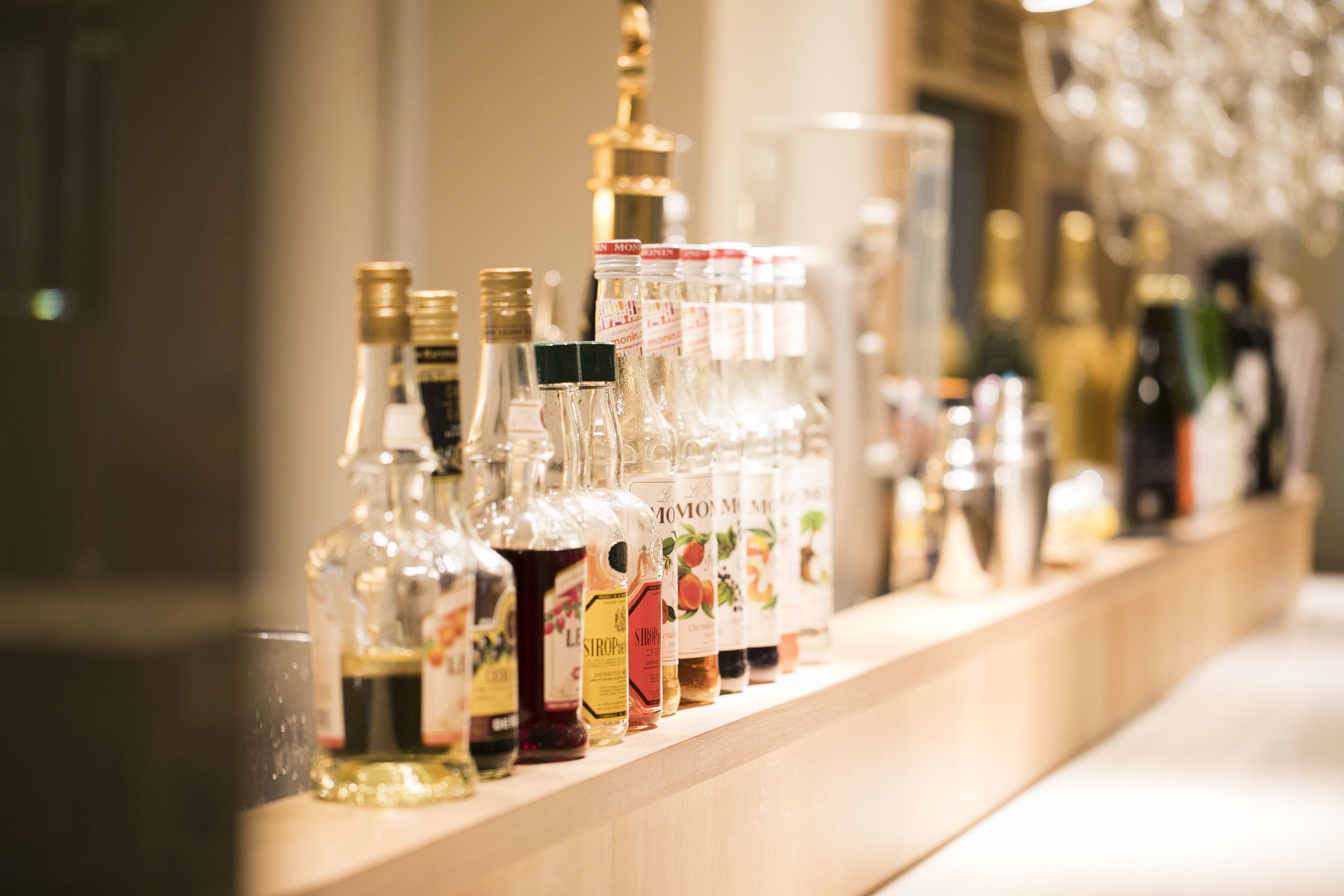 Zona de bar con varias botellas de licores y vasos.