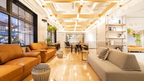 A modern interior with leather sofas, a dining area, and wooden beams on the ceiling. - Fukuoka Toei Hotel (Fukuoka)