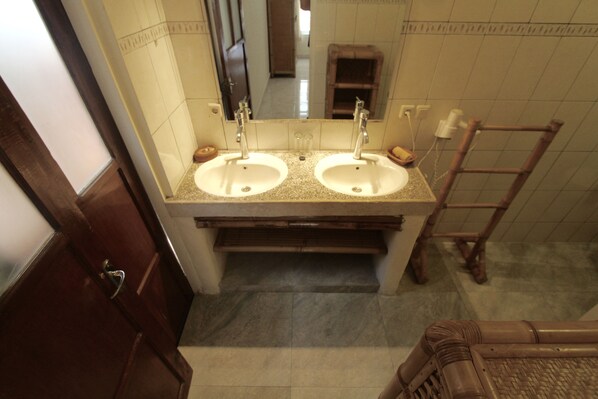 Un baño con dos lavamanos, un espejo y una escalera de madera.