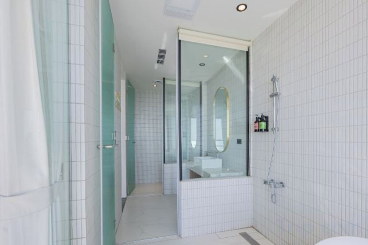 A modern bathroom with a glass shower enclosure, a white sink, and a toilet.