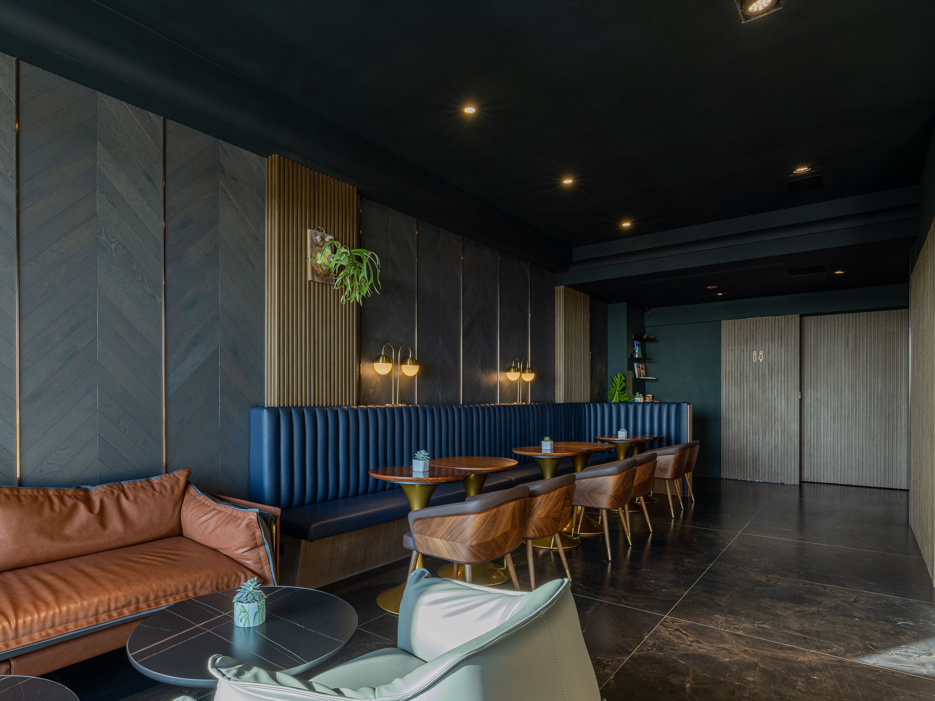 A modern interior with a seating area, tables, and a bar.