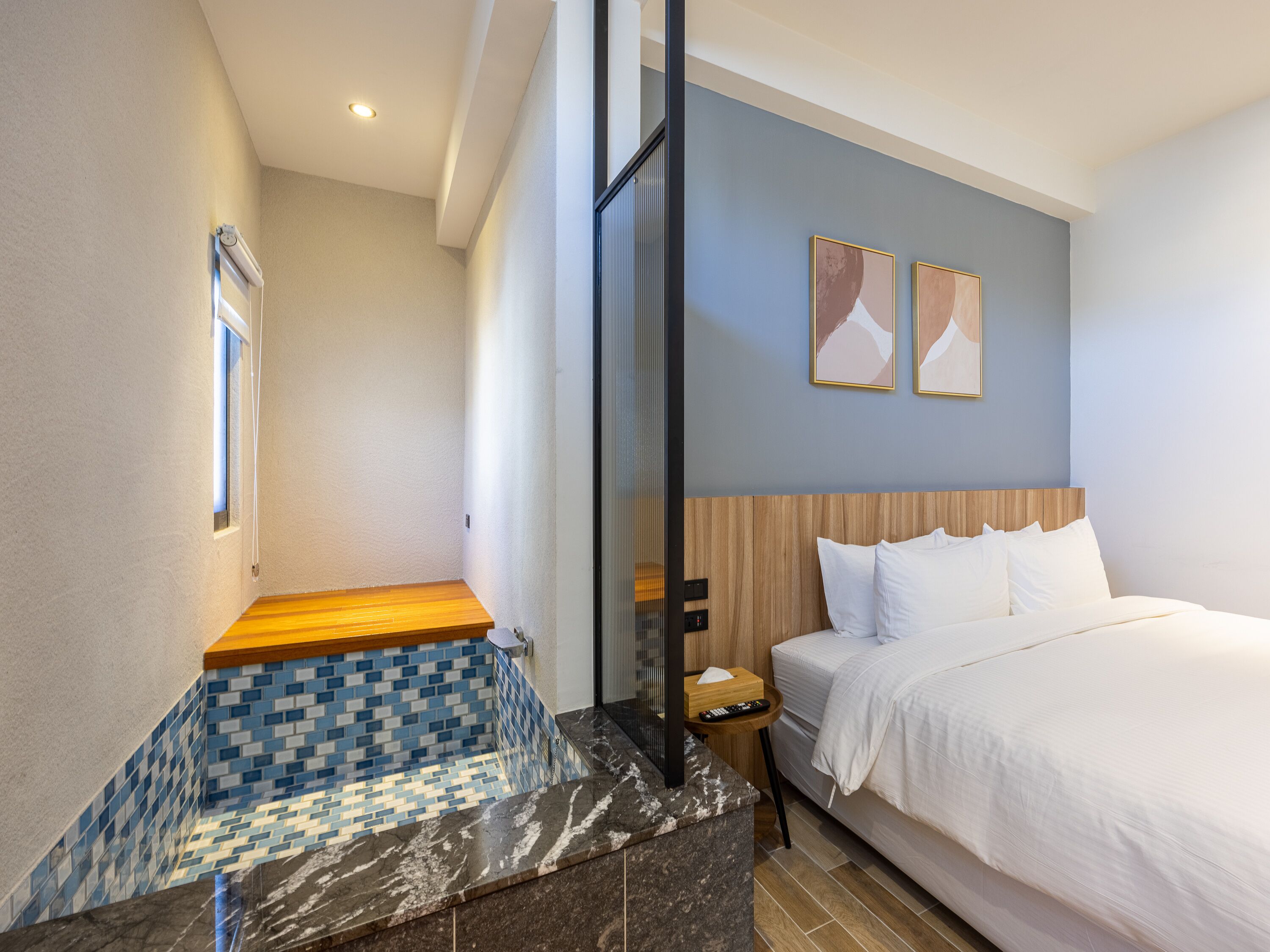 Habitación de hotel con cama, mesita de noche, ventana y suelo de baldosas.