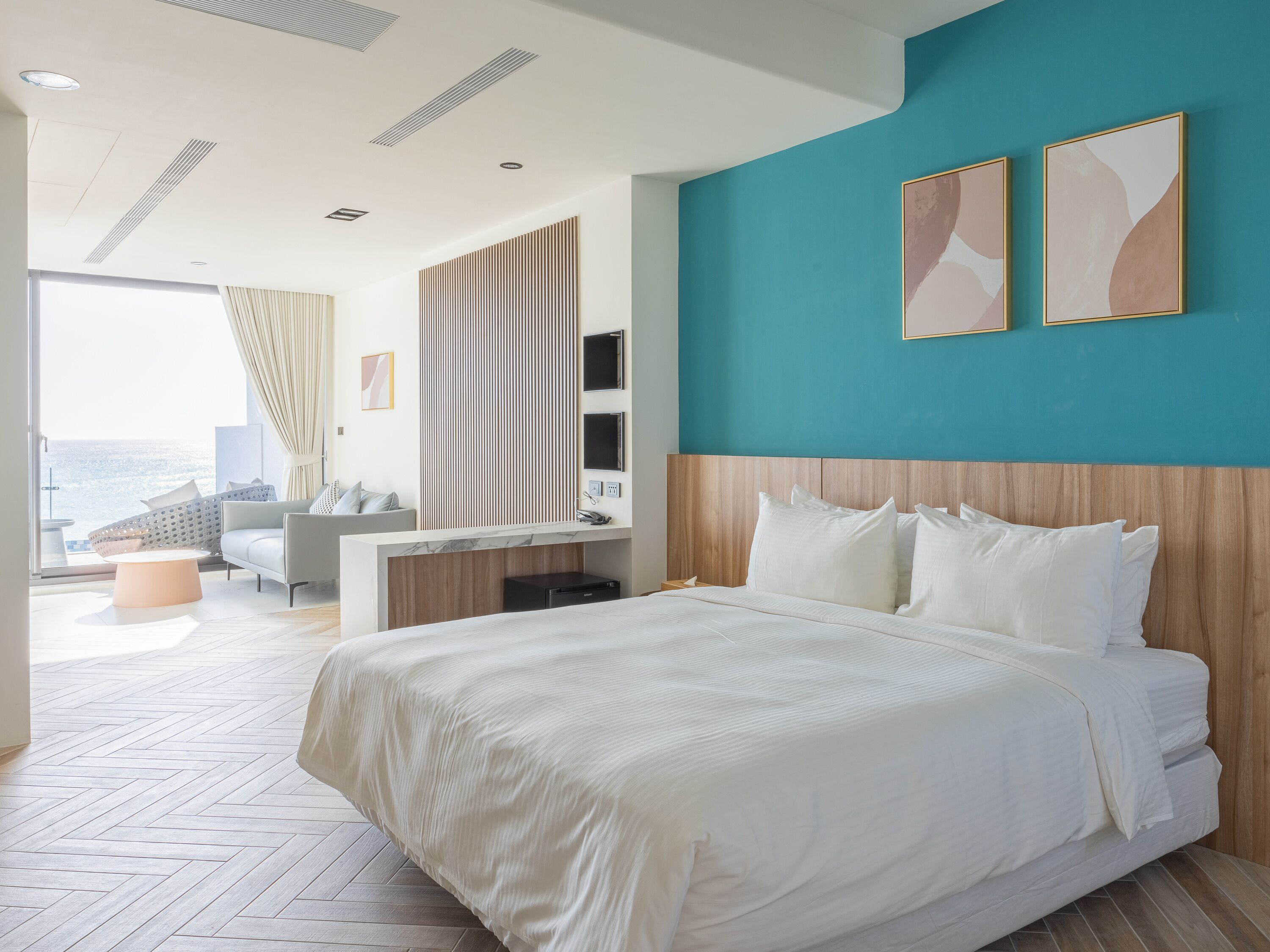 Ein modernes Hotelzimmer mit einem großen Bett, einem Schreibtisch und Blick auf die Stadt.