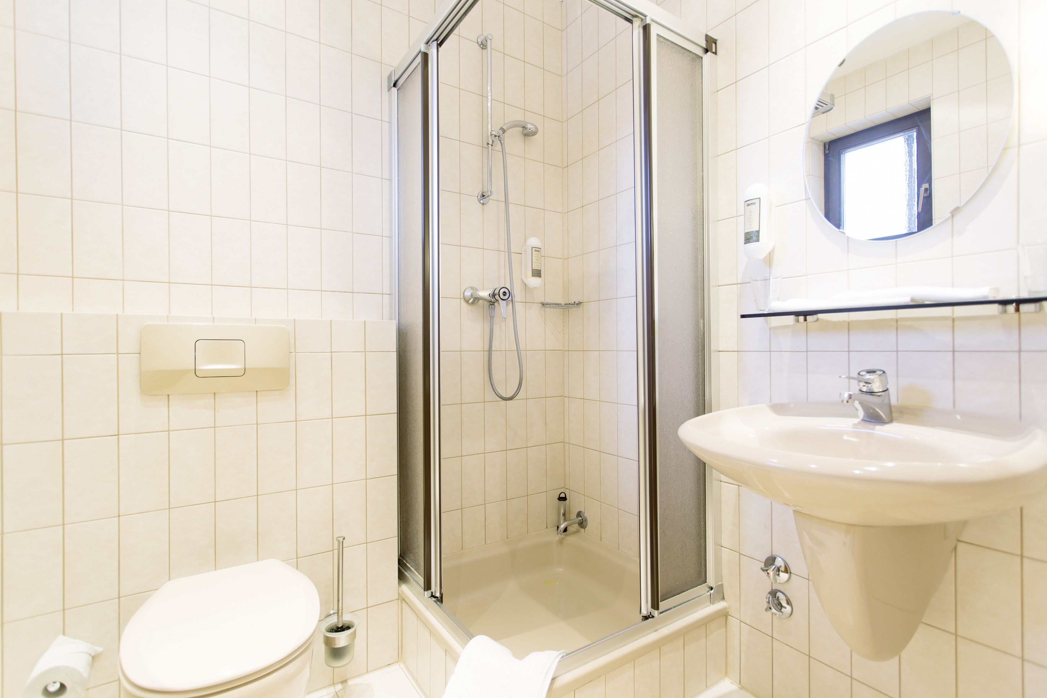 A bathroom with a toilet, a sink, and a glass-enclosed shower.
