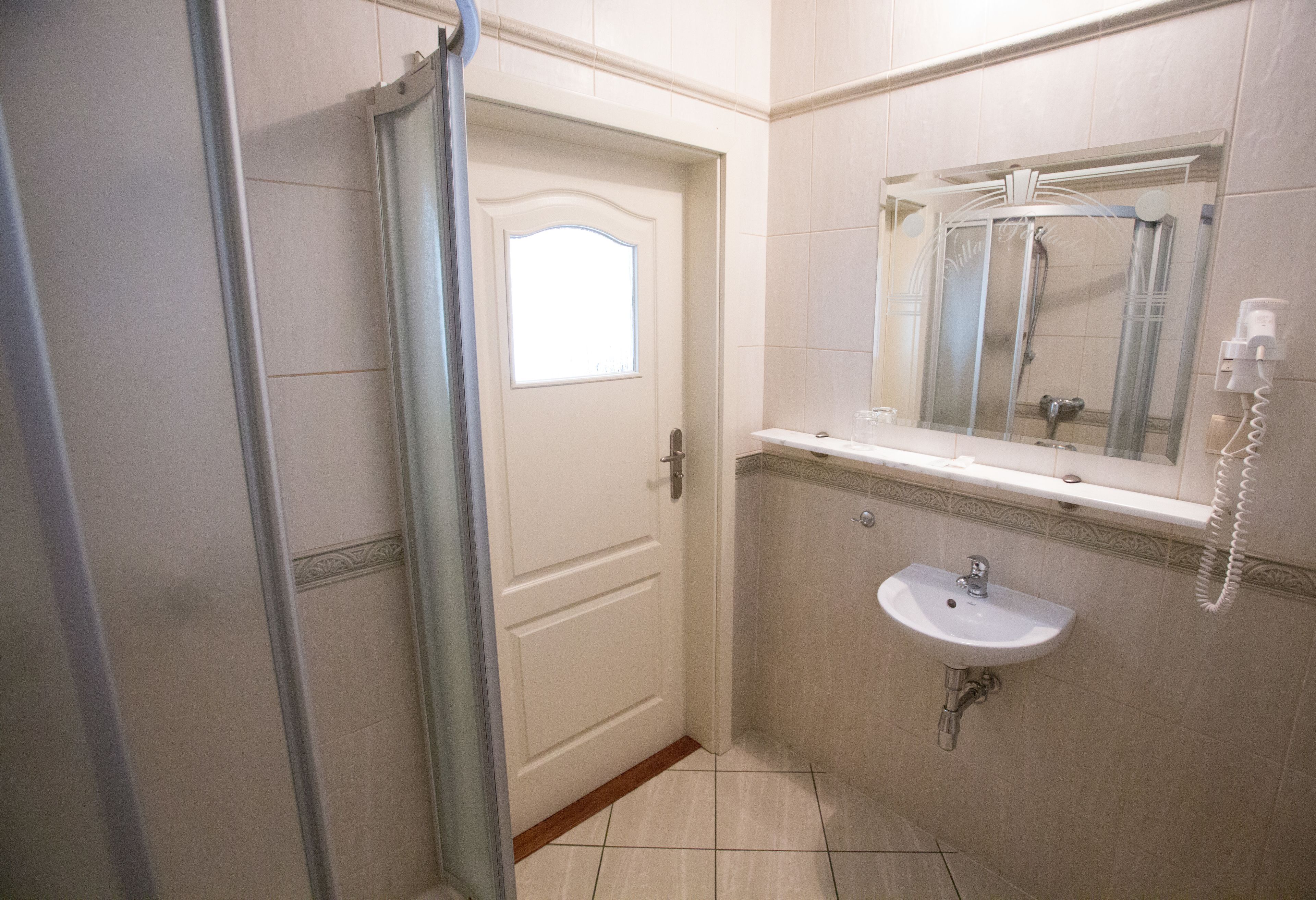 A bathroom with a shower, a sink, and a mirror.