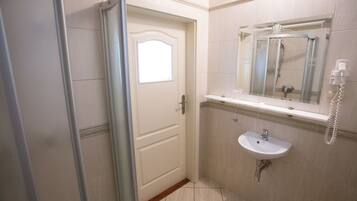 A bathroom with a shower, a sink, and a mirror.