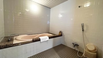 Ein Badezimmer mit Badewanne, Dusche und Toilette.