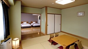 Una habitación de hotel con una mesa de madera, sillas, una cama y un armario.