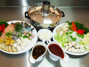 Una mesa con diversos platos, incluyendo mariscos, arroz y verduras.