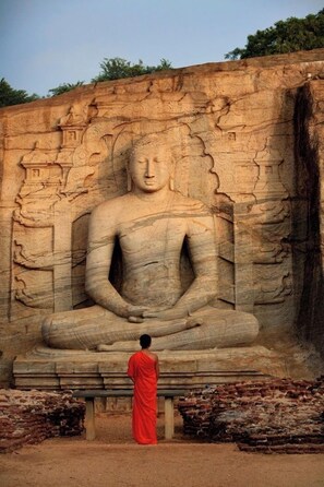 A large seated Buddha statue with intricate carvings on the wall behind it. - Aavya Cove Villas By Aahaasa (Balapitiya)