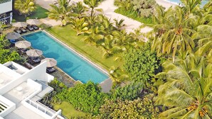 A resort with a swimming pool, lounge chairs, and a beach view. - Aavya Cove Villas By Aahaasa (Balapitiya)
