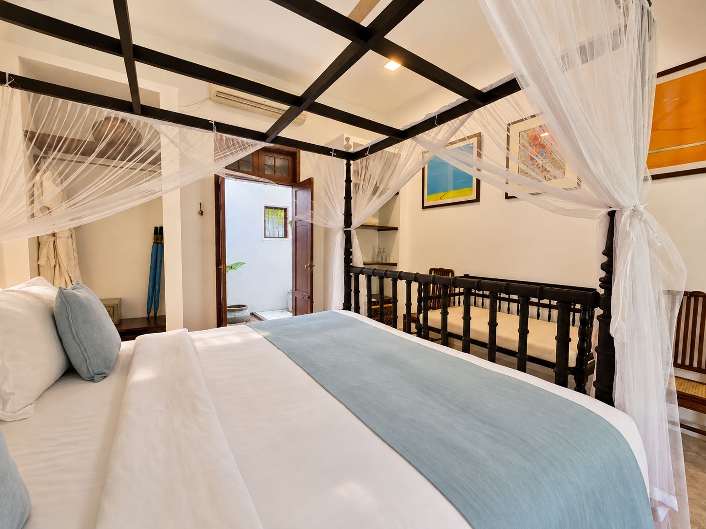 Un dormitorio con una cama, un cabecero de madera y un dosel.