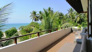A balcony with a view of the ocean and palm trees. - Aavya Cove Villas By Aahaasa (Balapitiya)