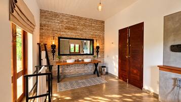 Un baño con un espejo grande, dos lavamanos, un mueble de tocador de madera y una zona de ducha.