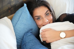 A person lying in bed with a blue pillow and white bedding. - Hotel Restaurant Brasserie Ahoi, Kortrijk (Kortrijk)