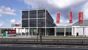 A modern building with a 'Welcome' sign, multiple flags, and a clear sky. - Hotel Restaurant Brasserie Ahoi, Kortrijk (Kortrijk)