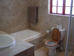A bathroom with a bathtub, toilet, and sink. - Ascot Gardens Self Catering (Cape Town)