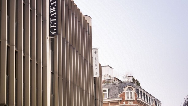 A modern building with a vertical sign reading "GETAWAY SHORT STAY". - Getaway Leuven (Leuven)