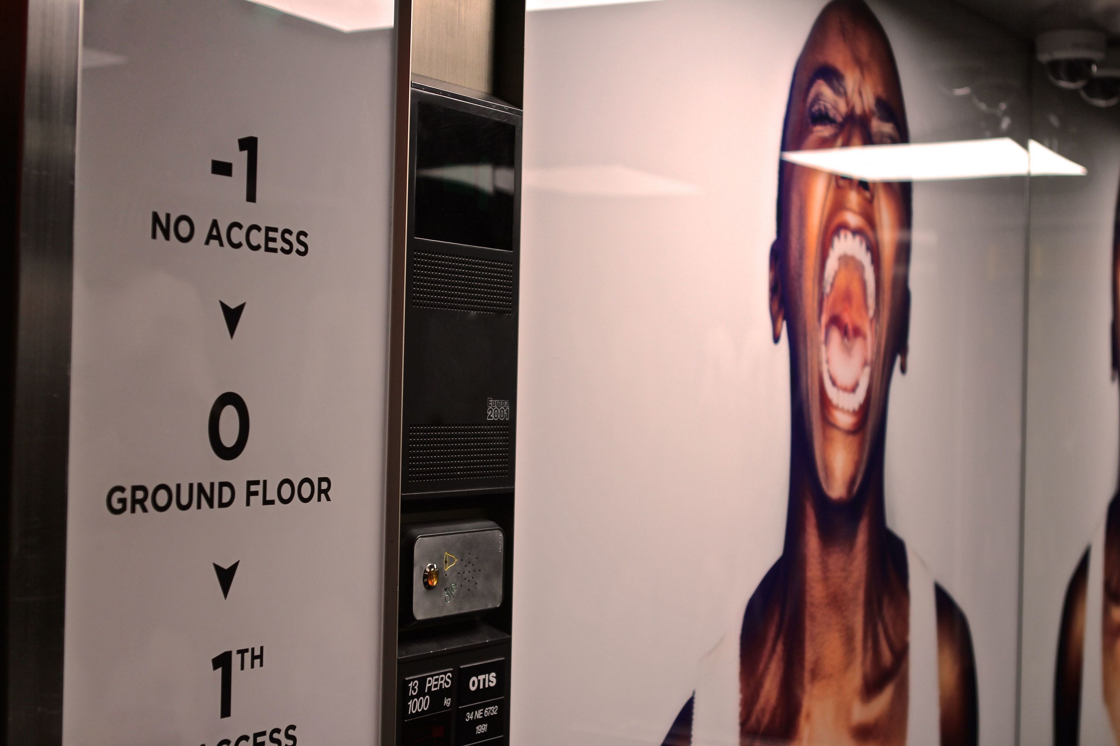 An elevator interior with a sign indicating no access to the 1st floor and ground floor.