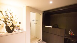 A reception area with a reception desk, a vase with white flowers, and a door with the text "CELTICAY". - Getaway Leuven (Leuven)