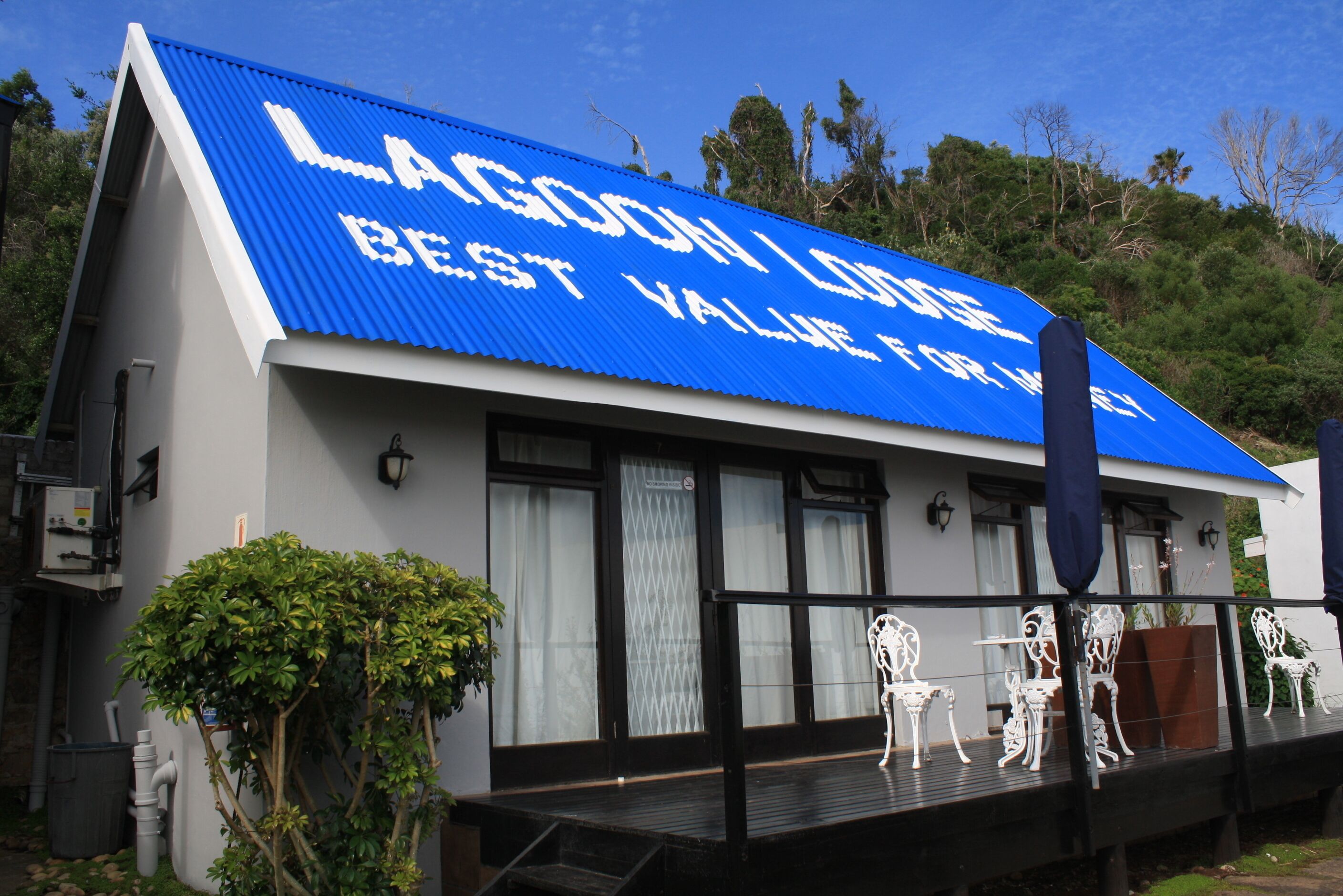 Un edificio con techo azul y un letrero que dice "Lagoon Lodge Best Value for Money".