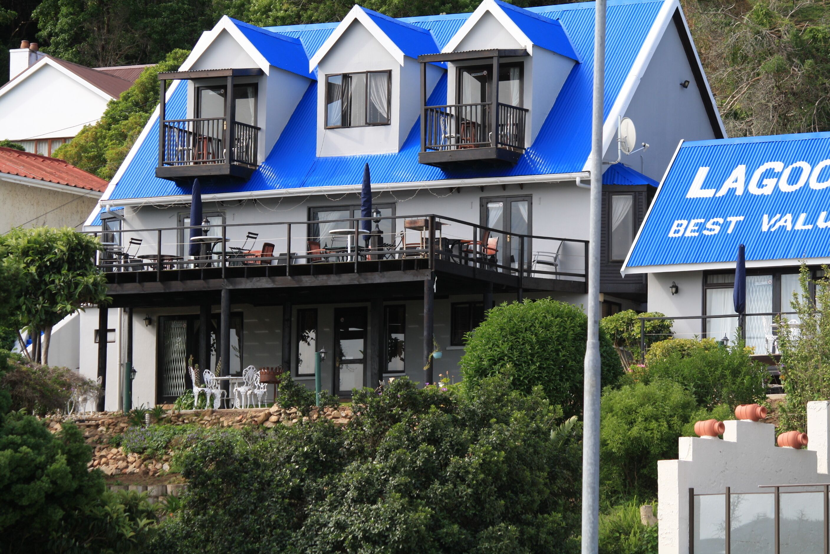 Un edificio de dos pisos con techo azul y balcones.
