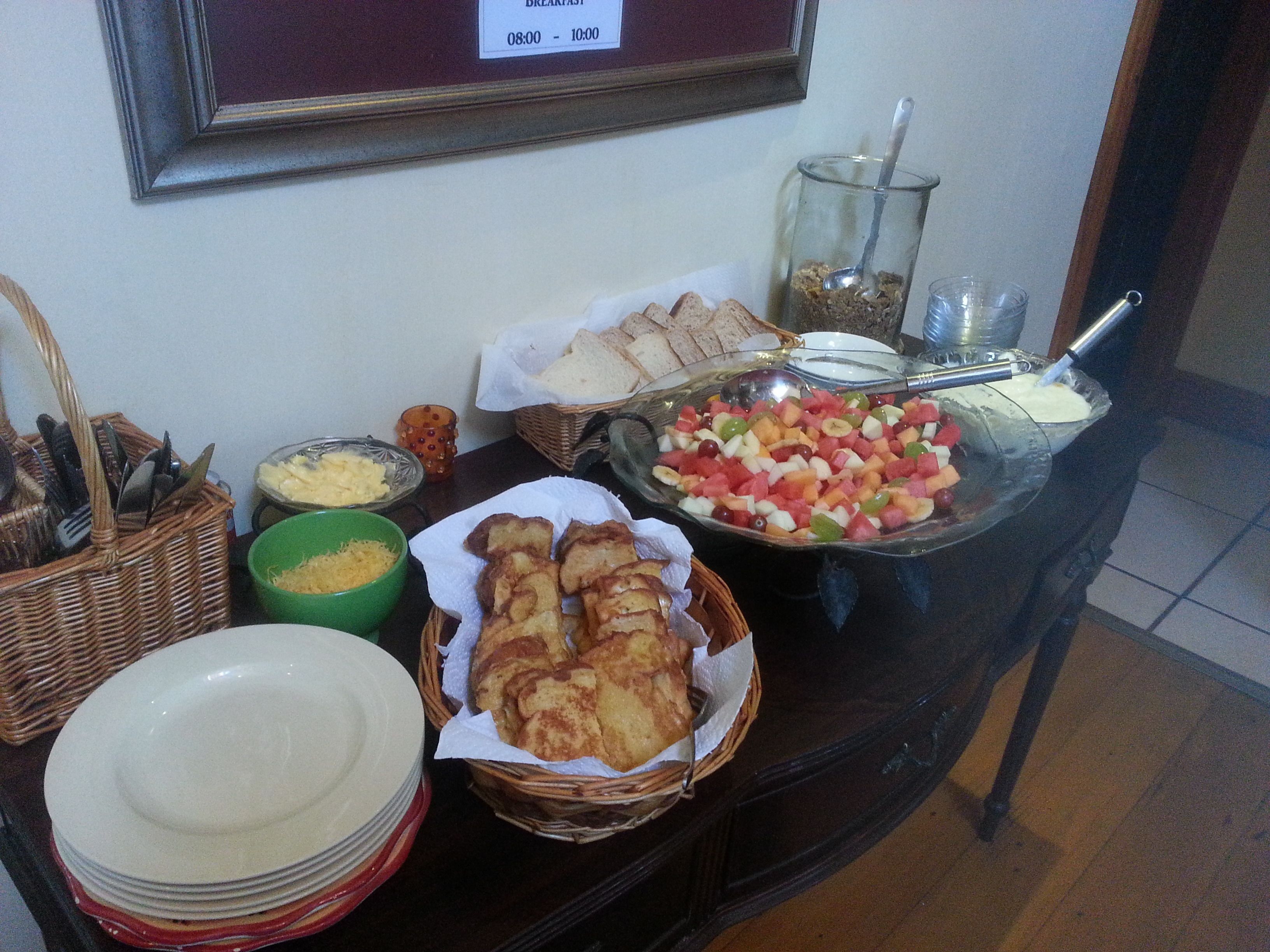 A breakfast buffet with various food items and utensils.