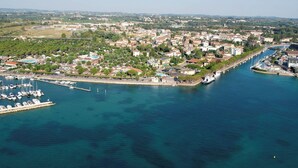 Vue aérienne d’une ville côtière avec un port de plaisance, des immeubles résidentiels et un pont reliant la ville au continent.
