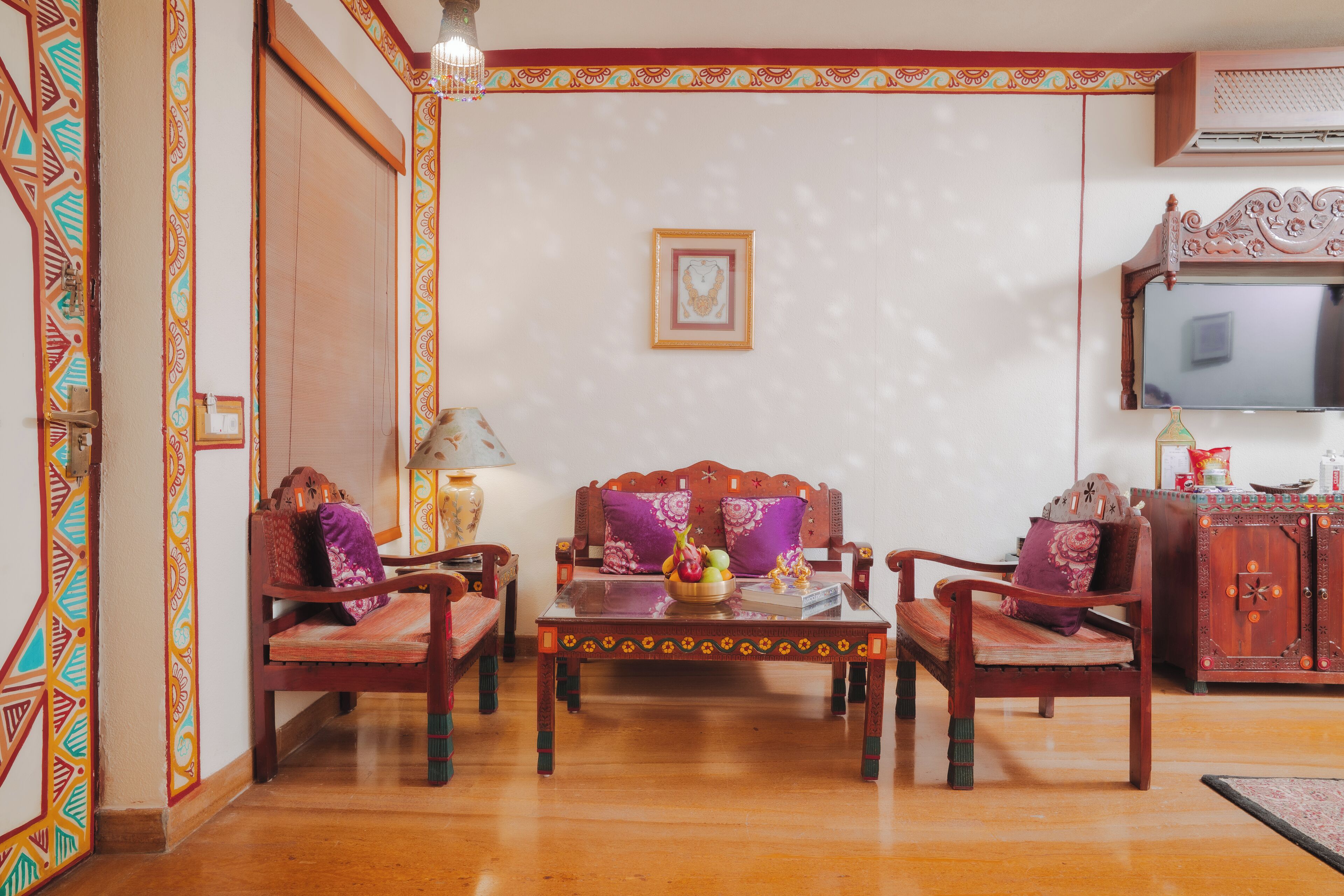 Un salón tradicional con un conjunto de sofás, una mesa de centro y un televisor.