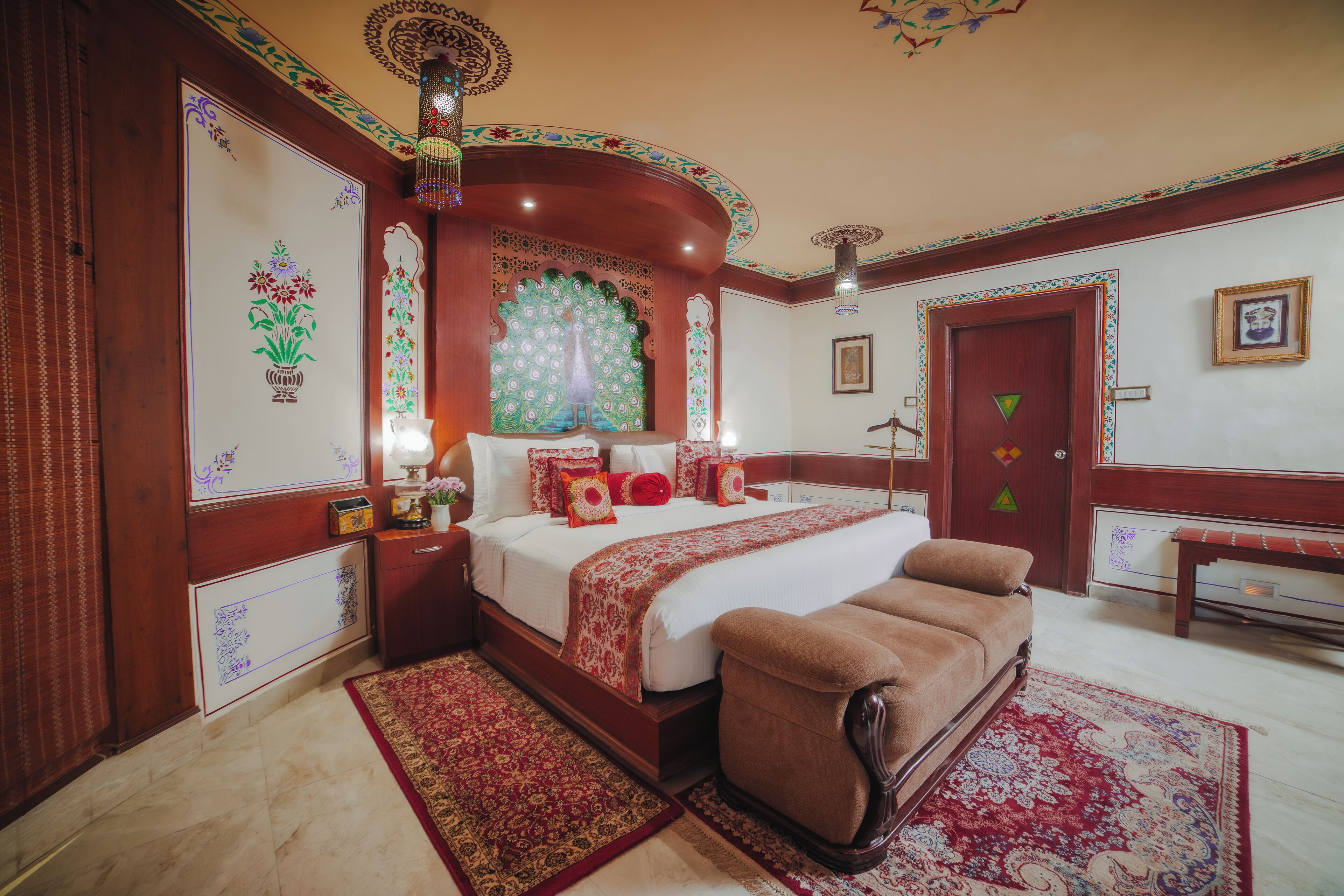 A traditional room with a large bed, a bench, and ornate decorations.