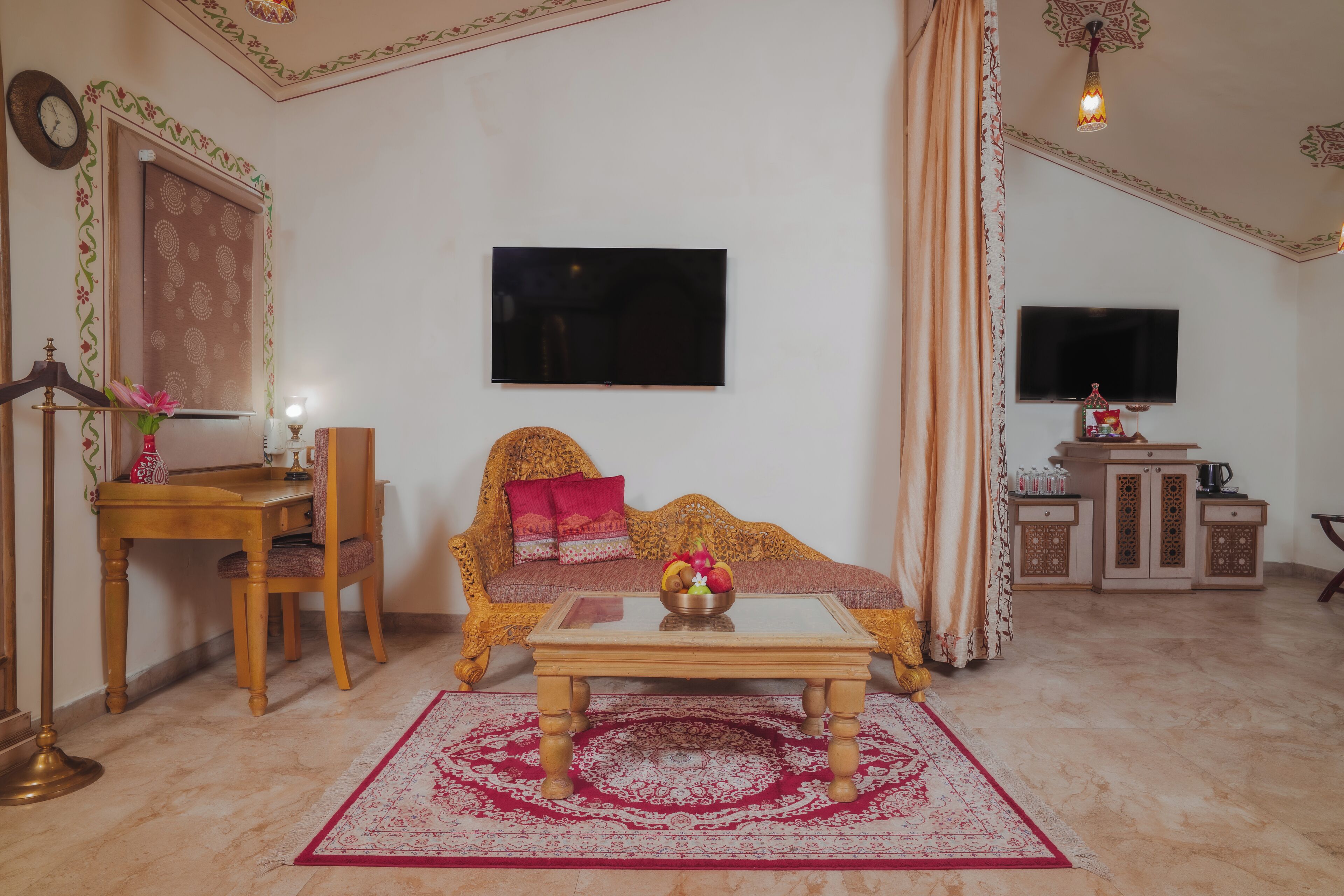 A living room with a sofa, a coffee table, a television, a cabinet, and a decorative rug.